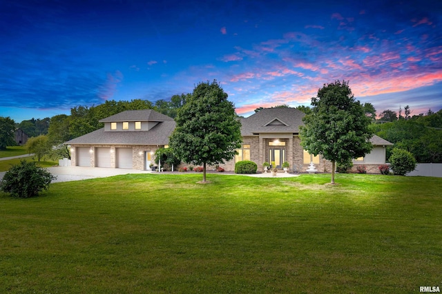 view of front of house featuring a garage and a lawn