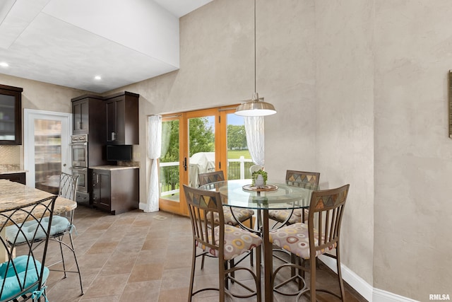 dining space featuring a towering ceiling