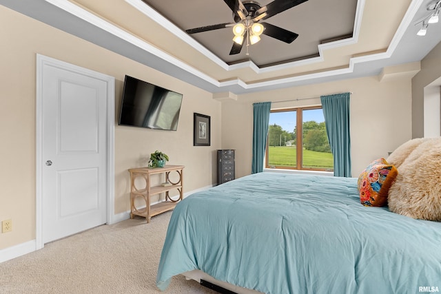 bedroom with a raised ceiling, crown molding, light colored carpet, and ceiling fan