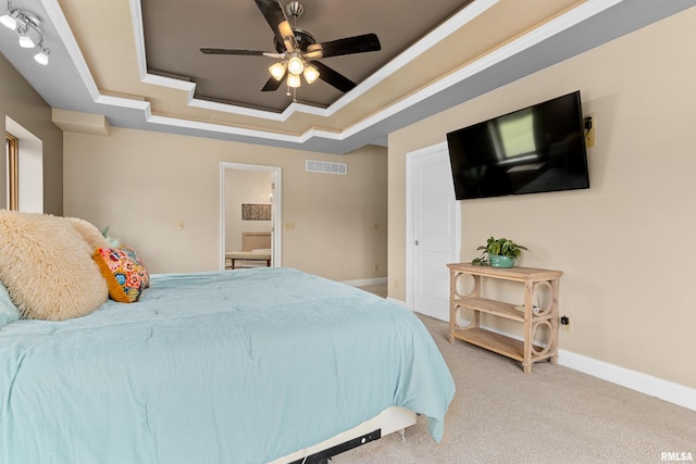 carpeted bedroom with ceiling fan, ornamental molding, and a tray ceiling