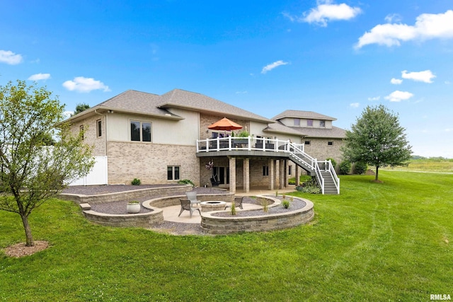 rear view of house with a patio area, a yard, a deck, and a fire pit