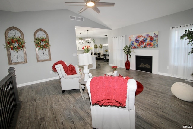 living room featuring vaulted ceiling, dark hardwood / wood-style floors, and ceiling fan with notable chandelier