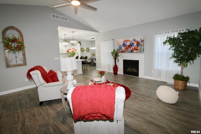 living room with vaulted ceiling, dark wood-type flooring, and ceiling fan with notable chandelier