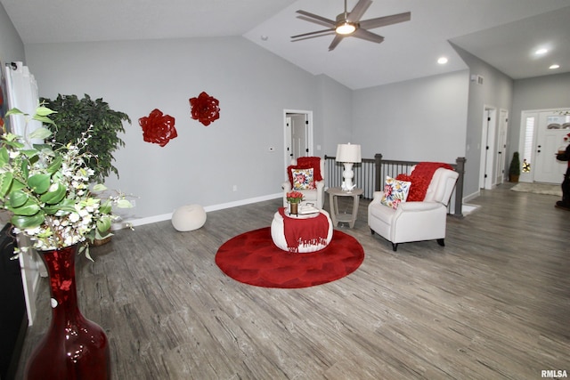 living area featuring lofted ceiling, dark hardwood / wood-style floors, and ceiling fan