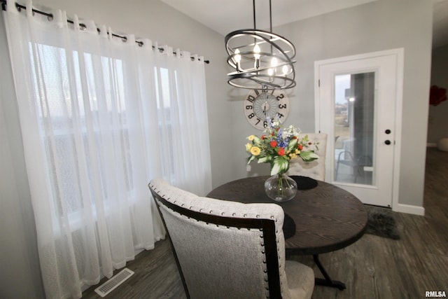 dining space with dark hardwood / wood-style flooring and a chandelier