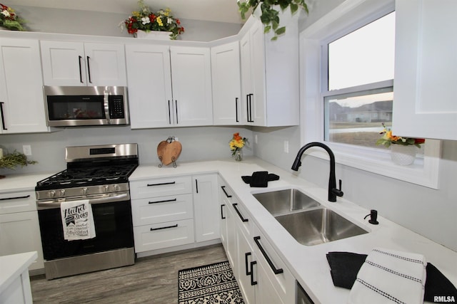 kitchen featuring appliances with stainless steel finishes, sink, and white cabinets