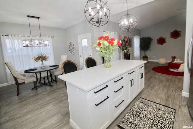 kitchen featuring a notable chandelier, decorative light fixtures, a center island, and white cabinets