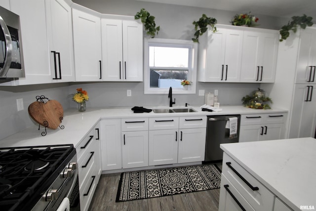 kitchen with white cabinetry, stainless steel appliances, dark wood-type flooring, and sink