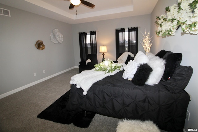 bedroom with carpet flooring, ceiling fan, and a tray ceiling