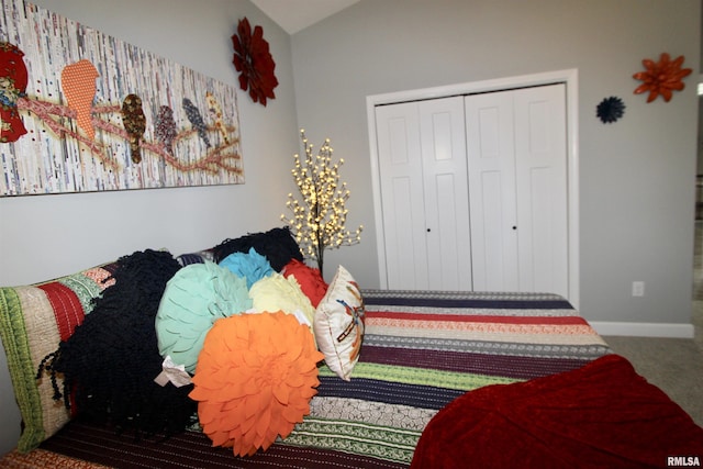 carpeted bedroom with vaulted ceiling and a closet