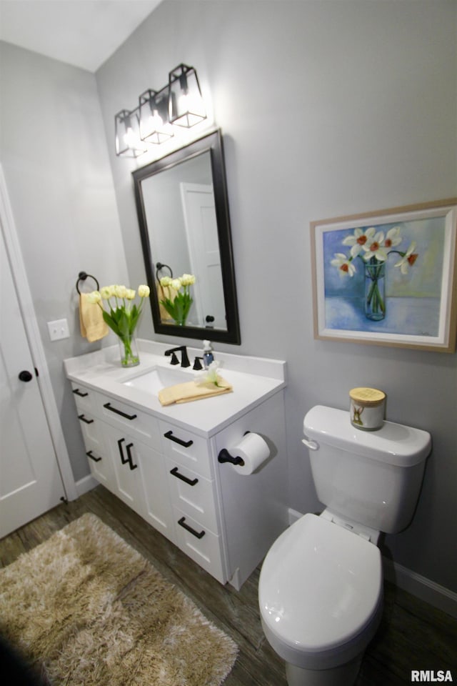 bathroom with vanity, wood-type flooring, and toilet