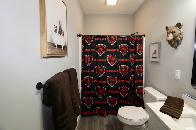 bathroom with hardwood / wood-style flooring, vanity, curtained shower, and toilet