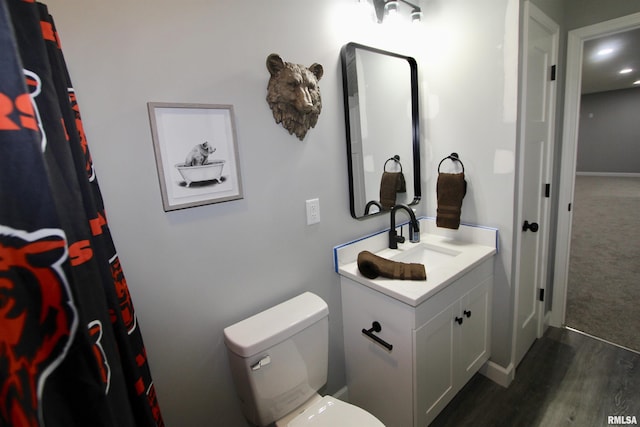 bathroom with vanity, toilet, and hardwood / wood-style floors