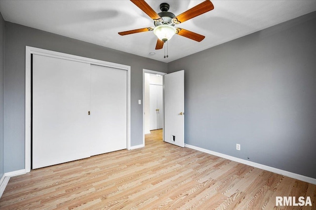 unfurnished bedroom featuring ceiling fan, light wood-type flooring, and a closet