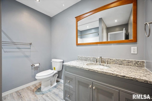 bathroom featuring hardwood / wood-style flooring, vanity, and toilet