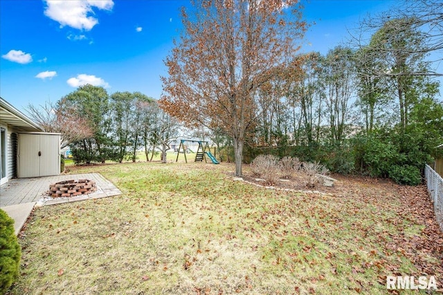 view of yard with a playground and an outdoor fire pit