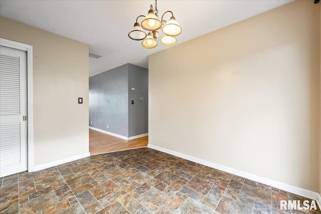 spare room with a notable chandelier