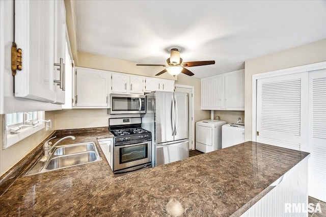 kitchen featuring appliances with stainless steel finishes, white cabinetry, sink, washing machine and clothes dryer, and kitchen peninsula