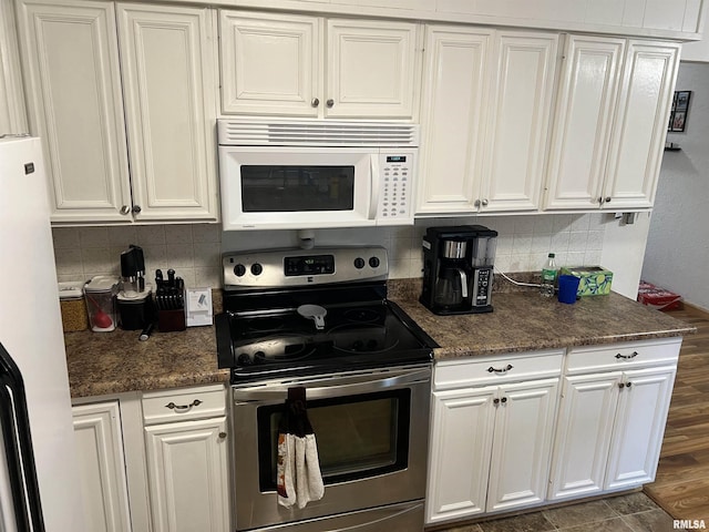 kitchen with white cabinetry, dark hardwood / wood-style flooring, white appliances, dark stone counters, and backsplash