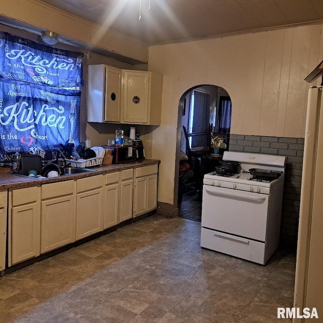 kitchen with cream cabinets, sink, and gas range gas stove