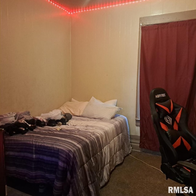 carpeted bedroom featuring wood walls