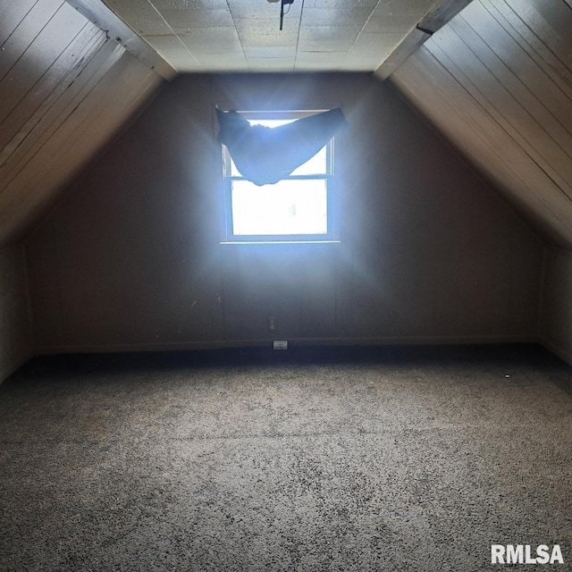 additional living space featuring lofted ceiling and carpet flooring