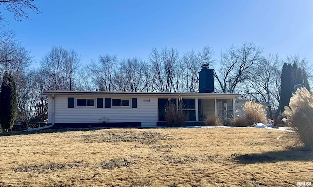 rear view of house with a yard and a sunroom