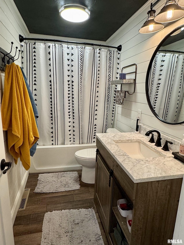 full bathroom with shower / tub combo with curtain, vanity, toilet, and wood walls