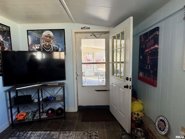 entryway with vaulted ceiling and dark tile patterned flooring