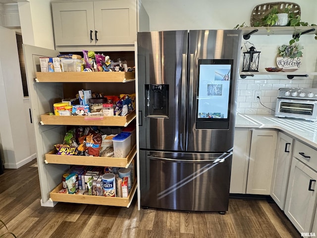 kitchen featuring dark hardwood / wood-style flooring, white cabinetry, stainless steel fridge, and tasteful backsplash