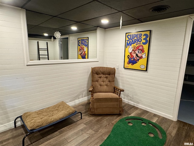 living area with hardwood / wood-style floors and a drop ceiling