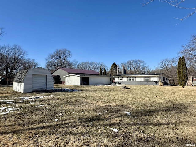 view of front of property with a front lawn and a storage shed