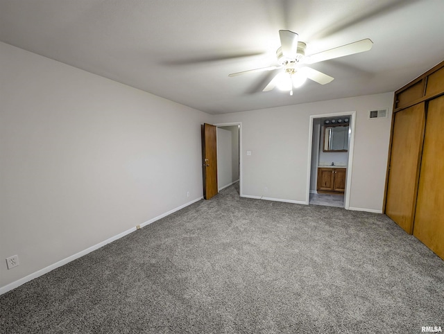 unfurnished bedroom featuring ensuite bathroom, carpet floors, sink, ceiling fan, and a closet