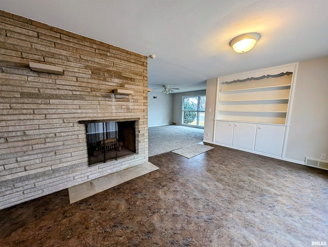 unfurnished living room featuring a brick fireplace, dark carpet, and ceiling fan