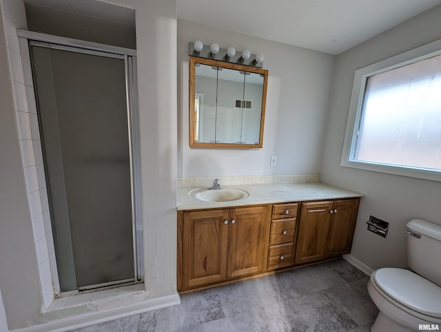 bathroom with vanity, toilet, and a shower with shower door