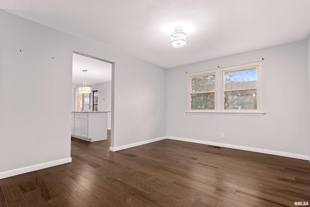 spare room with dark wood-type flooring and a wealth of natural light