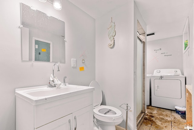 bathroom featuring toilet, vanity, and washer / clothes dryer