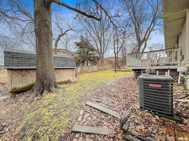 view of yard featuring a storage shed, a deck, and central air condition unit