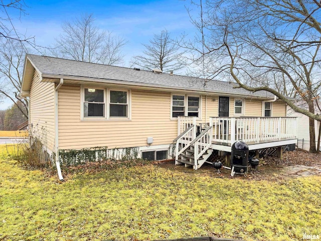 back of property with a deck and a lawn