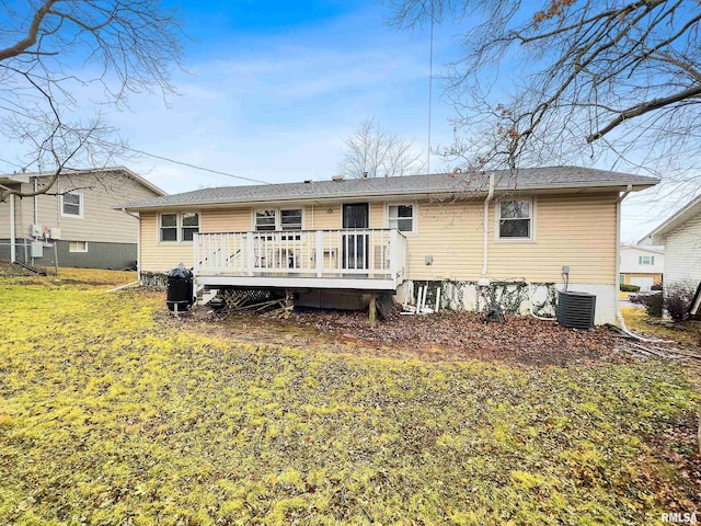 rear view of property with a wooden deck, central AC, and a lawn