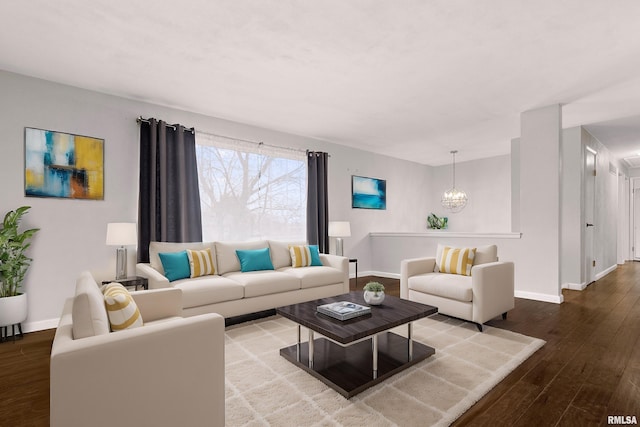 living room featuring wood-type flooring and an inviting chandelier