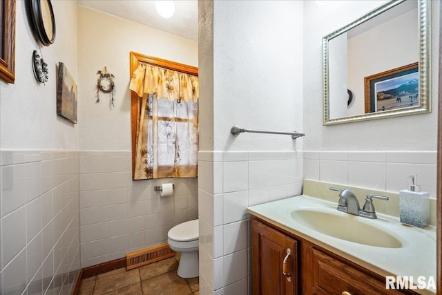 bathroom with vanity, tile walls, tile patterned floors, and toilet