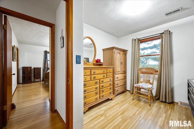 sitting room with a textured ceiling and light wood-type flooring