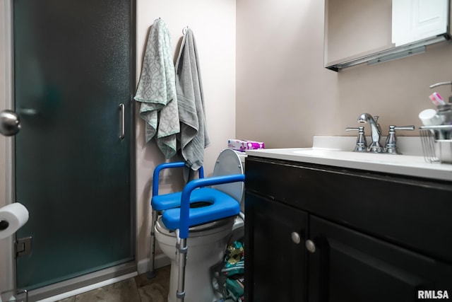 bathroom featuring vanity, an enclosed shower, and toilet