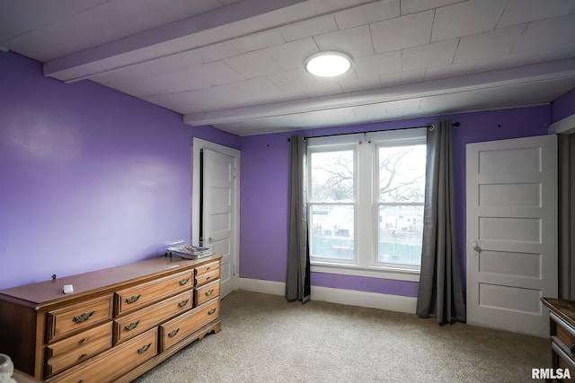 bedroom featuring beam ceiling and light colored carpet