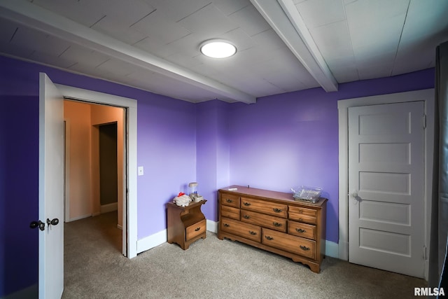 carpeted bedroom featuring beamed ceiling