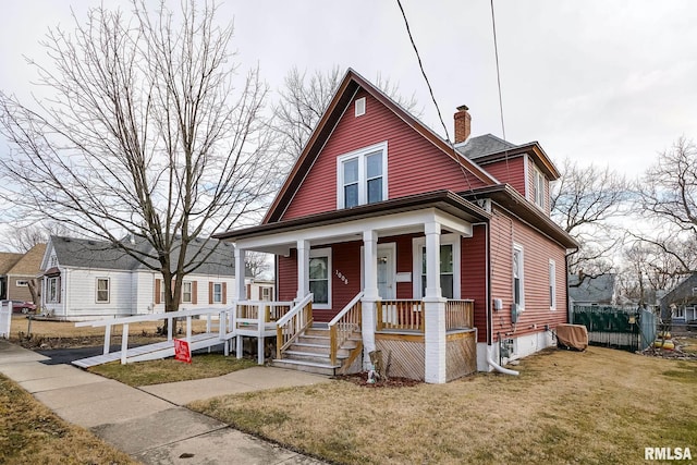 bungalow-style house with covered porch and a front lawn