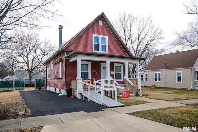 bungalow-style home with a front yard and covered porch