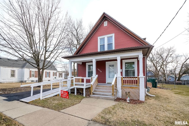 bungalow-style home with covered porch and a front lawn