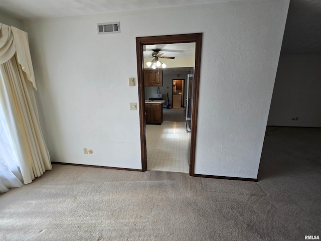 unfurnished room with ceiling fan and light colored carpet